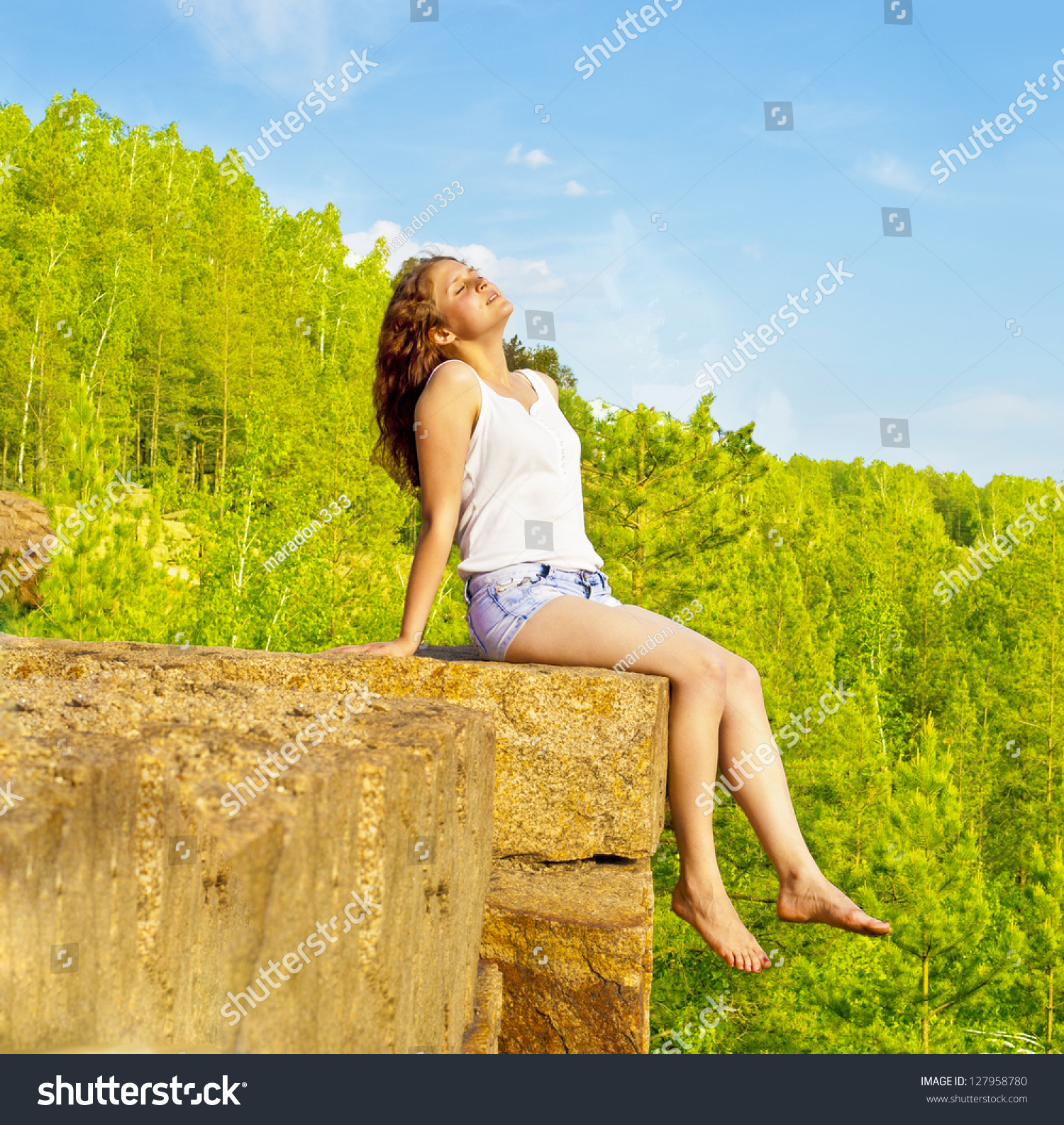 stock-photo-young-woman-sitting-on-cliff-s-edge-and-sleeping-on-mountain-slender-legs-dangling...jpg