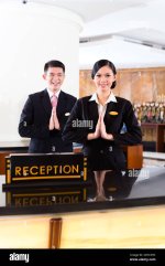 chinese-asian-reception-team-at-luxury-hotel-front-desk-welcoming-guests-with-typical-gesture-...jpg