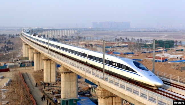 FILE - A high-speed train traveling to Guangzhou is seen running on Yongdinghe Bridge in Beijing, Dec. 26, 2012.