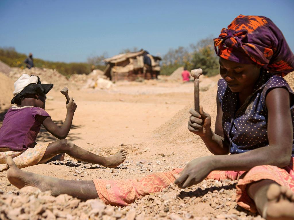 A child and a woman work in a cobalt pit in Lubumbashi. Picture: Junior Kannah/AFP