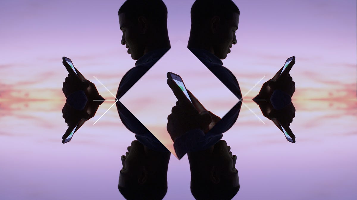 A stylized photo of a man using a smartphone, reflected left-to-right and top-and-bottom to show the image four times.