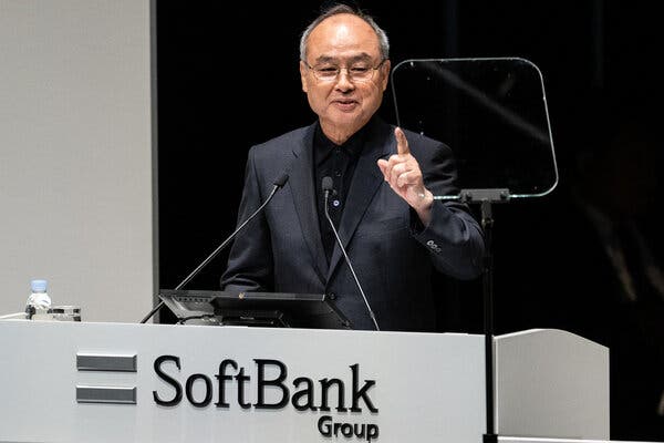 Masayoshi Son standing in front of a podium with the words SoftBank Group on it, speaking to a crowd. 