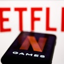 Netflix Games logo displayed on a phone screen and Netflix logo displayed on a screen are seen in th...