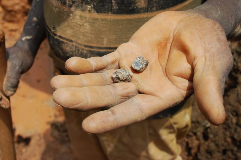 An artisanal miner in North Kivu holds cassiterite crystals, from which tin can be extracted: young people in Manono also dig for this mineral to sell to traders. Image by Laura Heaton/Enough Project via Flickr (CC BY-NC-ND 2.0).