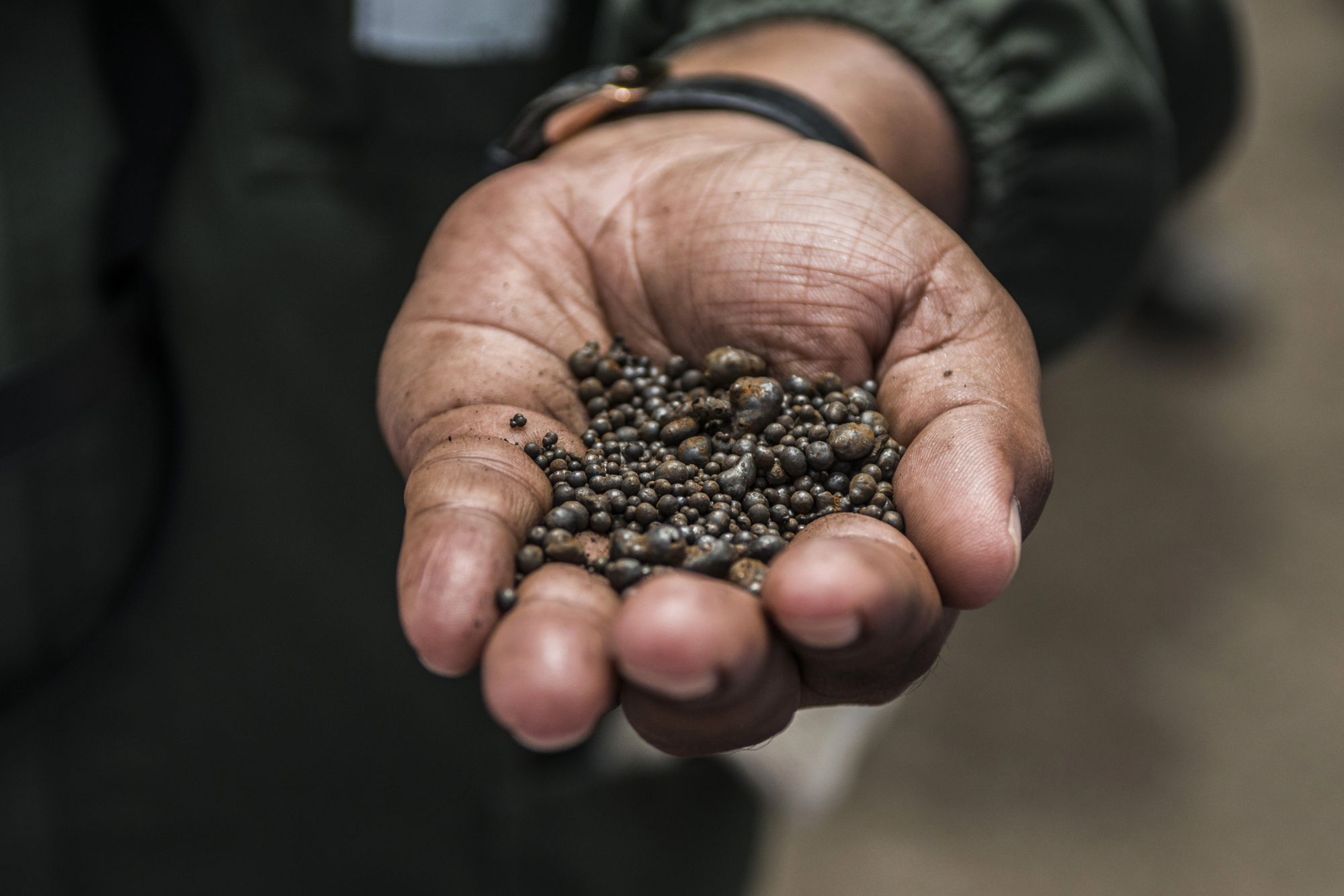 A mine worker with a handful of cobalt metal nuggets in Zambia.