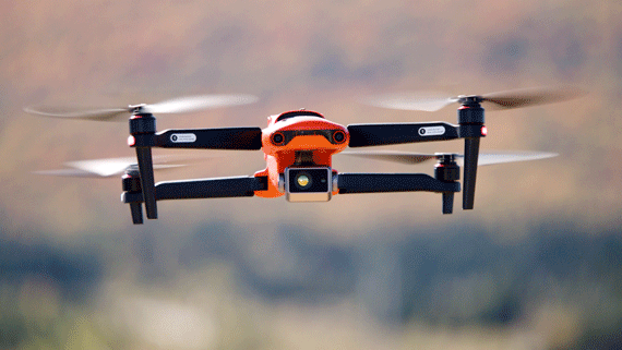 Orange drone being tested in the sky.